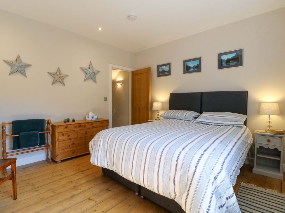 A bedroom with a bed and wooden furniture at 7 Catcliffe Cottages in Bakewell