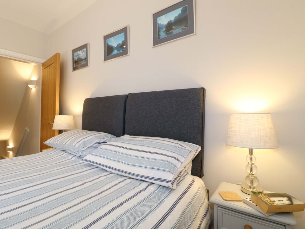 A bedroom with a bed and nightstand at 7 Catcliffe Cottages in Bakewell