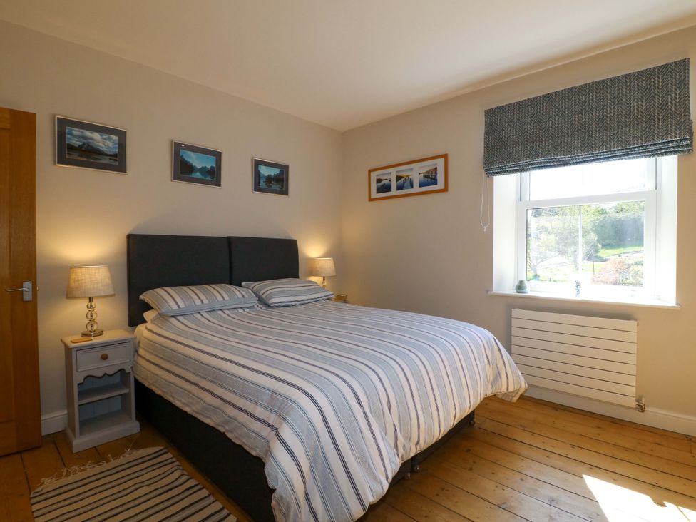A bedroom with a bed and nightstand at 7 Catcliffe Cottages in Bakewell