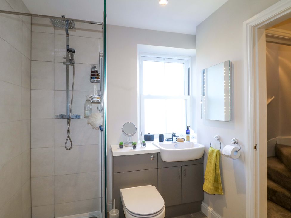 A bathroom with a shower, sink, and toilet at 7 Catcliffe Cottages, Bakewell