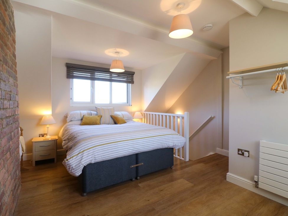 A bedroom with a bed and nightstand at 7 Catcliffe Cottages in Bakewell