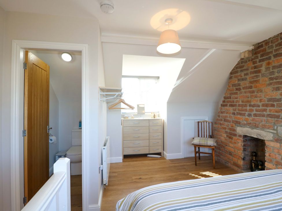 A bedroom with a bed, chair, and dresser at 7 Catcliffe Cottages Bakewell