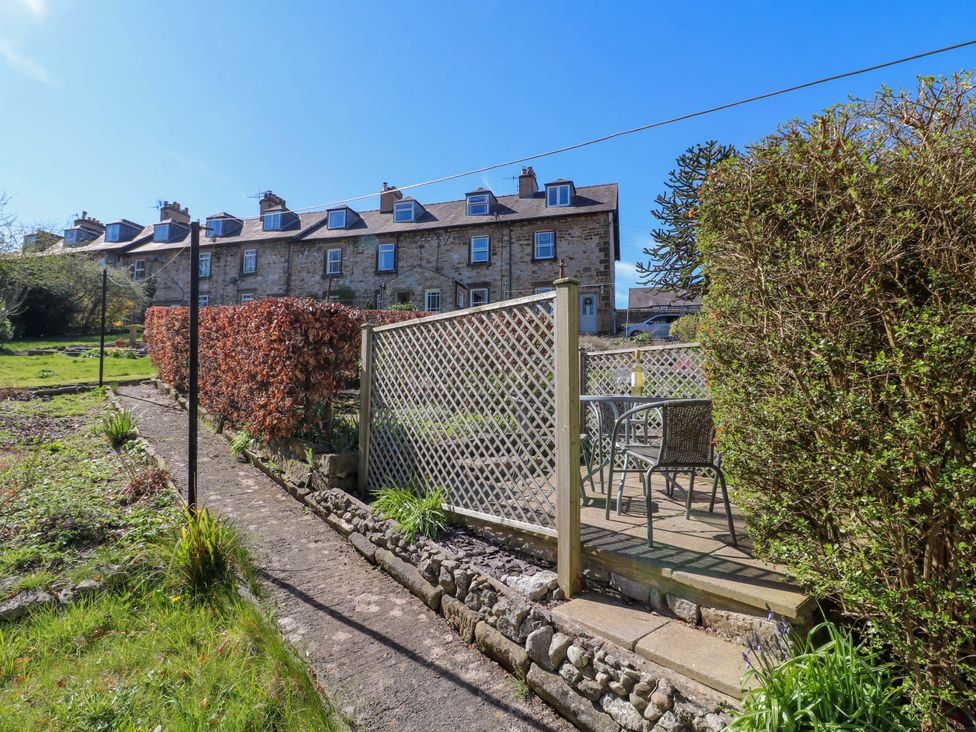 A garden with a fence, table, and chairs at 7 Catcliffe Cottages in Bakewell