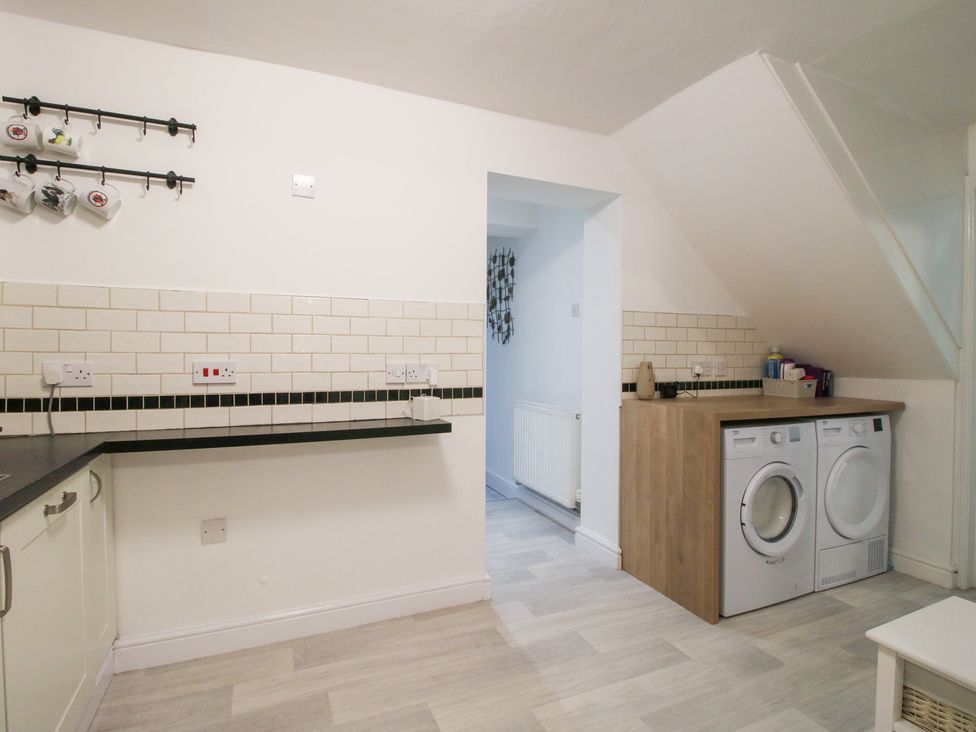 A utility room with washing machine and counter at 12 Beaufort Close in Telford