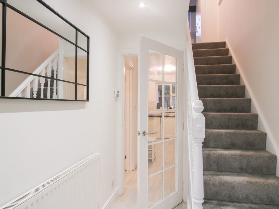 A hallway with a staircase and mirror at 12 Beaufort Close Telford