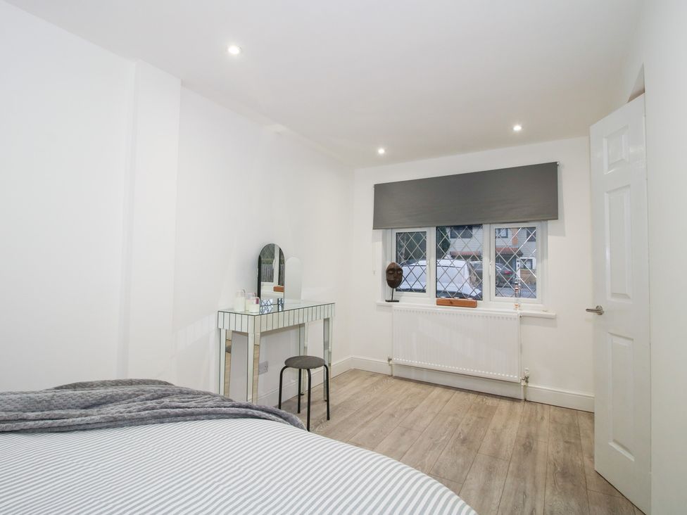 A bedroom with a bed and a mirror at 12 Beaufort Close Telford