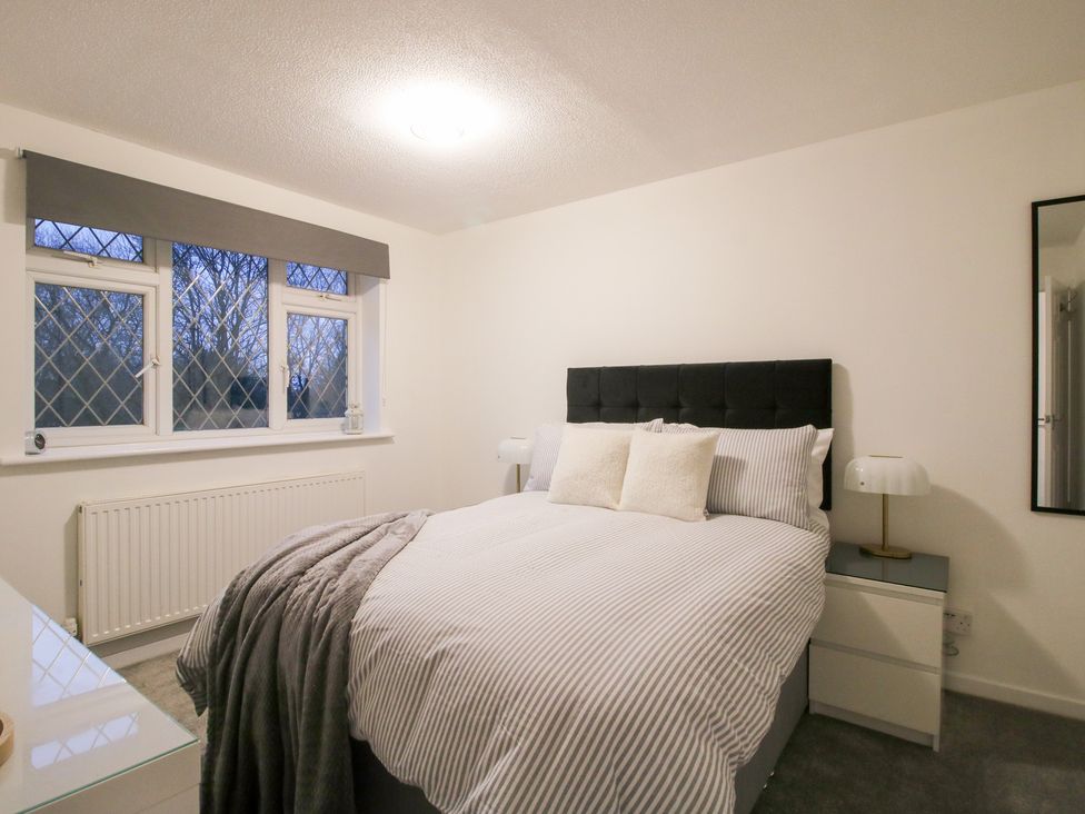 A bedroom with a bed and windows at 12 Beaufort Close Telford