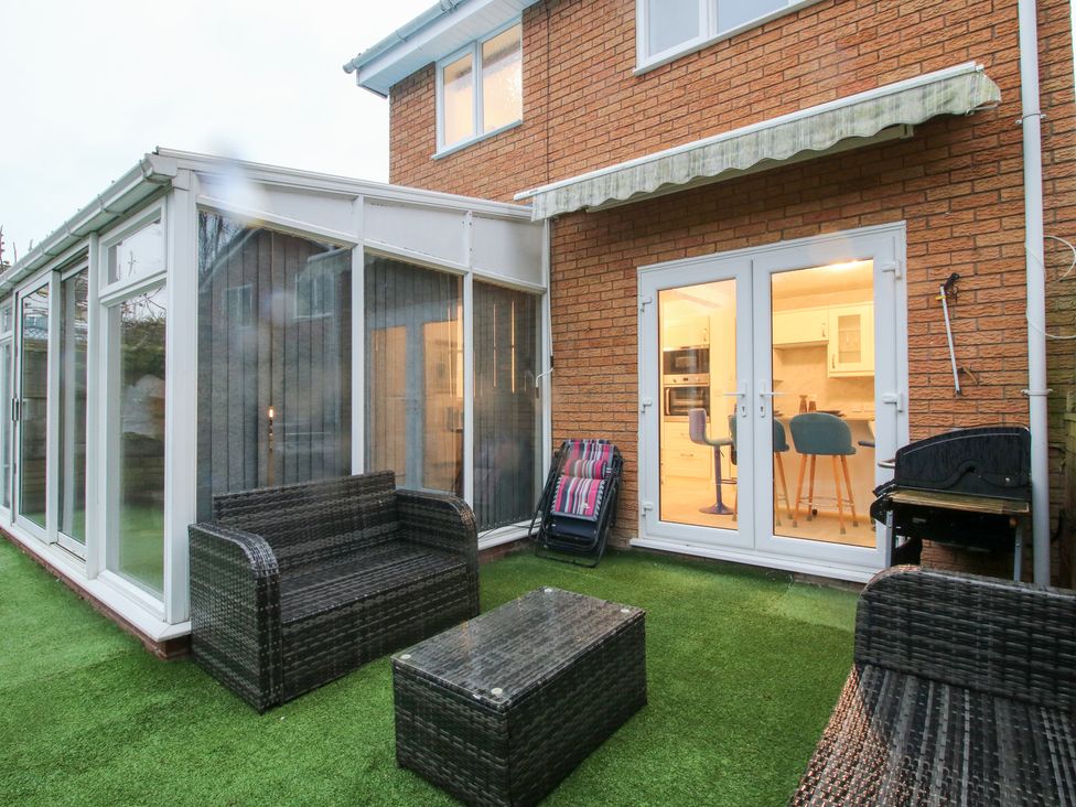A conservatory with outdoor seating and double doors at 12 Beaufort Close Telford