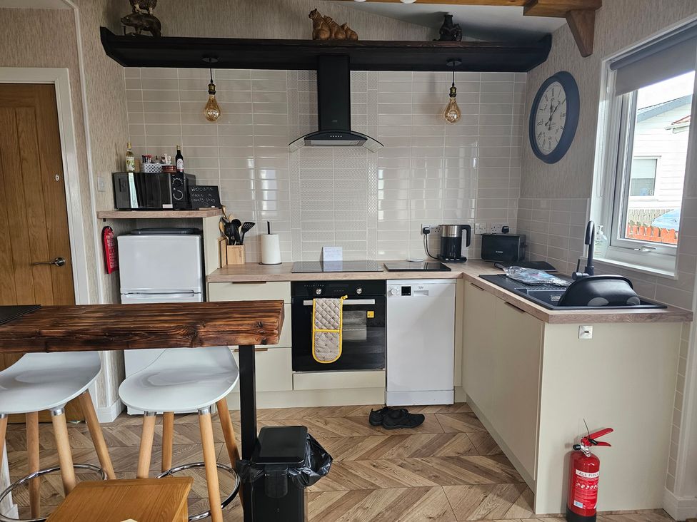 A kitchen with appliances and seating area at 38A in Bridlington