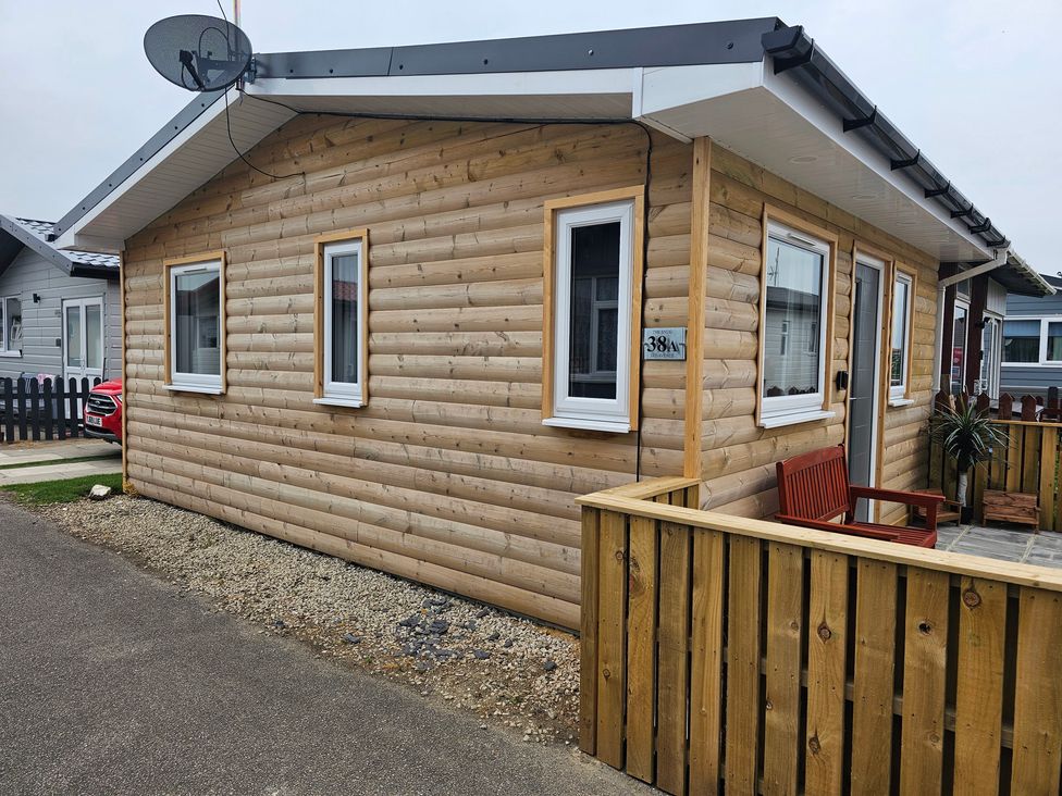 A wooden house with a satellite dish and a fence at 38A Bridlington