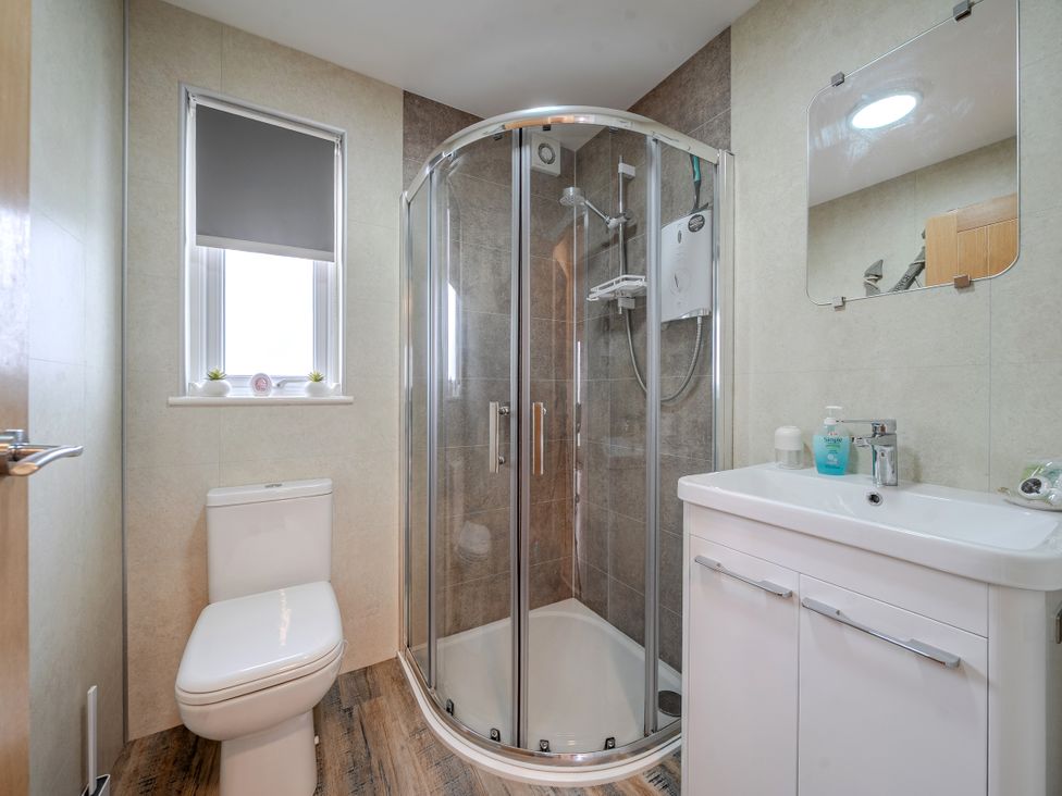 A bathroom featuring a shower, toilet, and sink at 38A in Bridlington