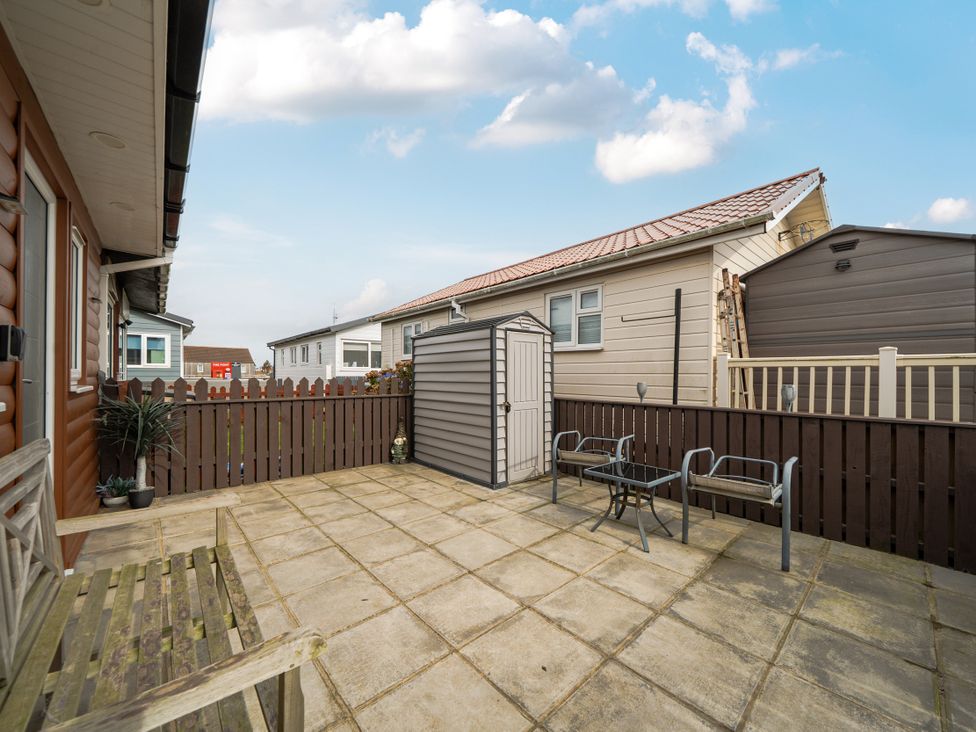 An outdoor patio area with a shed and seating at 38A in Bridlington