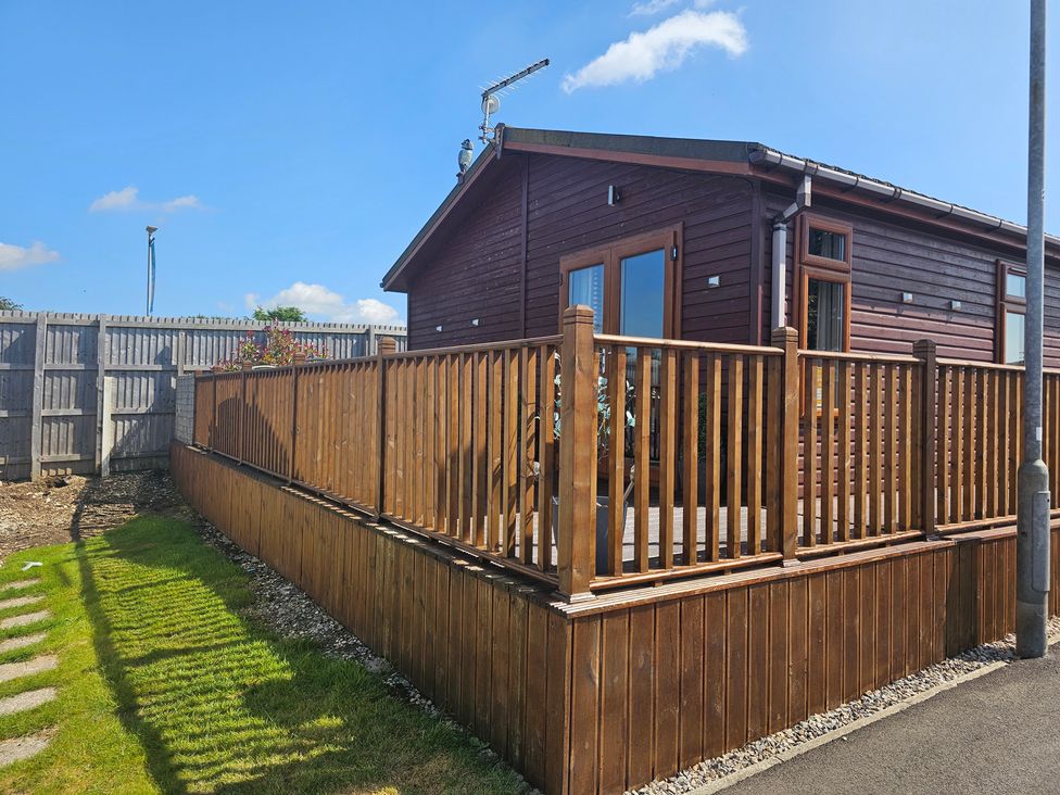 A wooden cabin with a deck and fencing at 311 Bridlington
