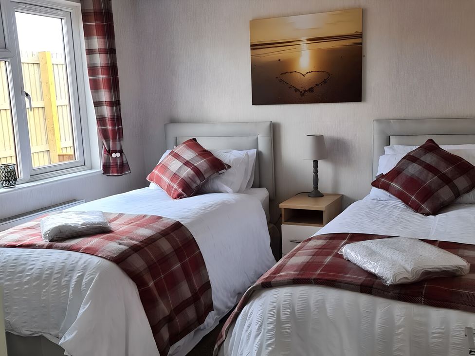 A bedroom with two beds and a bedside table at 311 in Bridlington