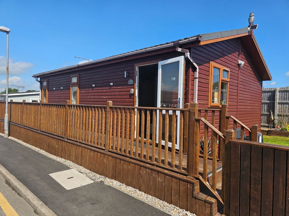 A house with a deck and fenced area at 311 Bridlington