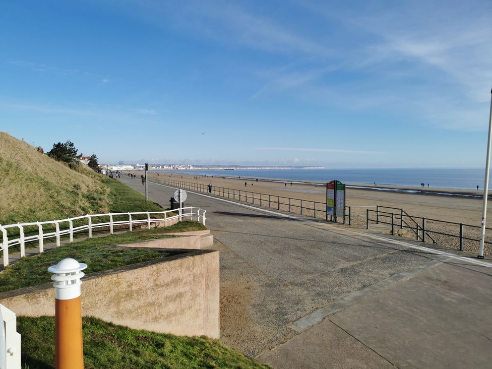 A beach view with people walking along the shore at 311 Bridlington