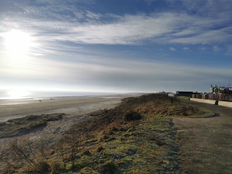 A beach view with people walking at 50 Bridlington