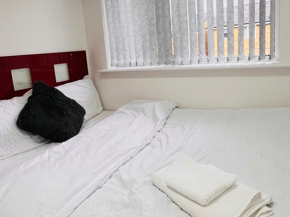 A bedroom with a bed and towels at Fairclough Close in Northolt