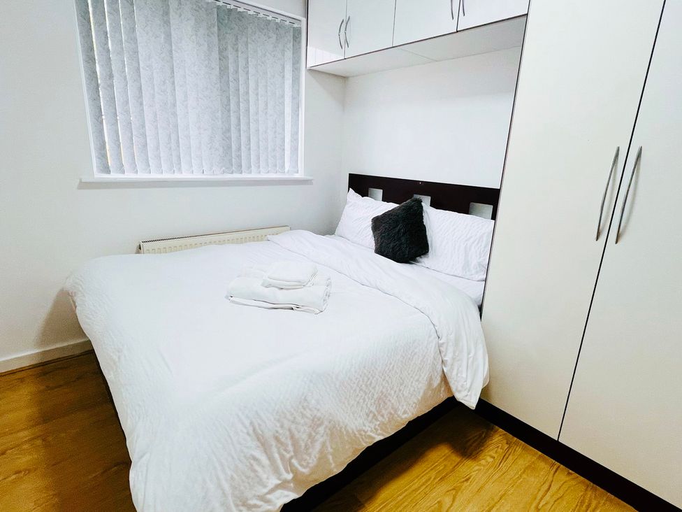 A bedroom with a bed and wardrobe at Fairclough Close Northolt
