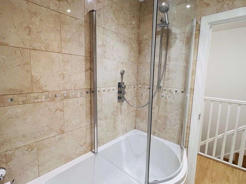 A bathroom with a shower over a bathtub at Fairclough Close in Northolt