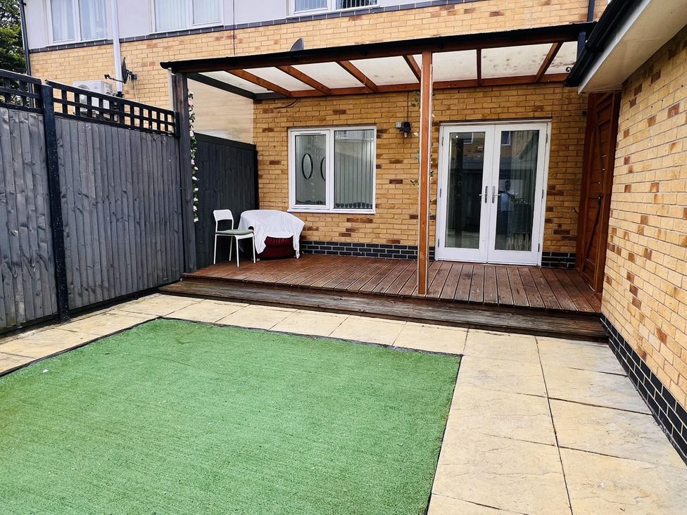 An outdoor area with decking and artificial grass at Fairclough Close in Northolt