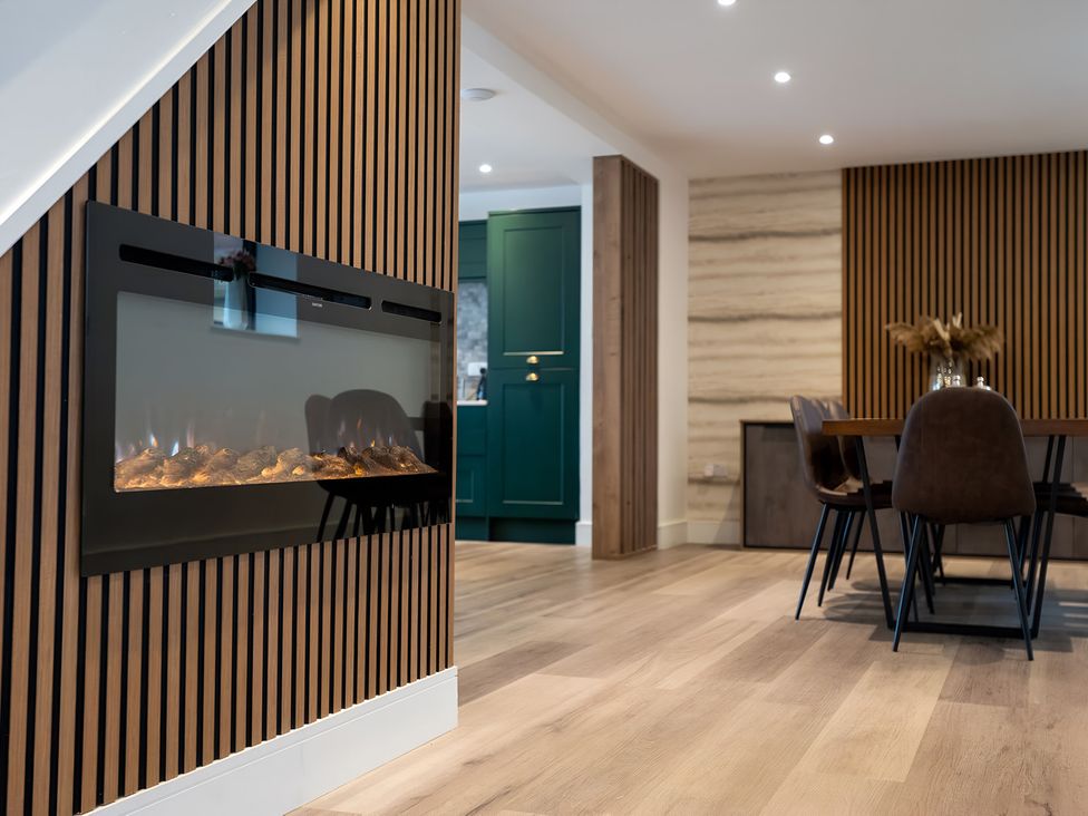 A dining room with an electric fireplace and dining table at The Galloway in Morpeth