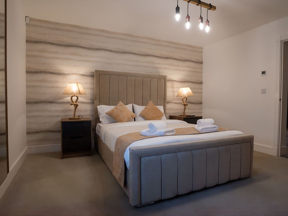 A bedroom with a bed and bedside tables at The Galloway in Morpeth