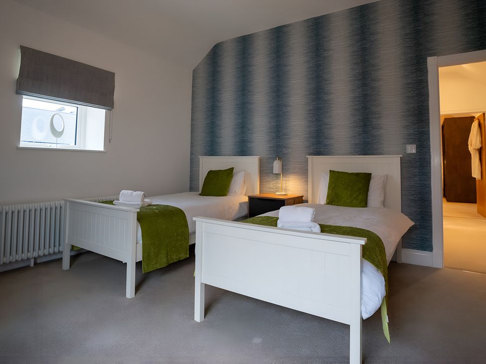 A bedroom with two beds and a nightstand at The Galloway in Morpeth