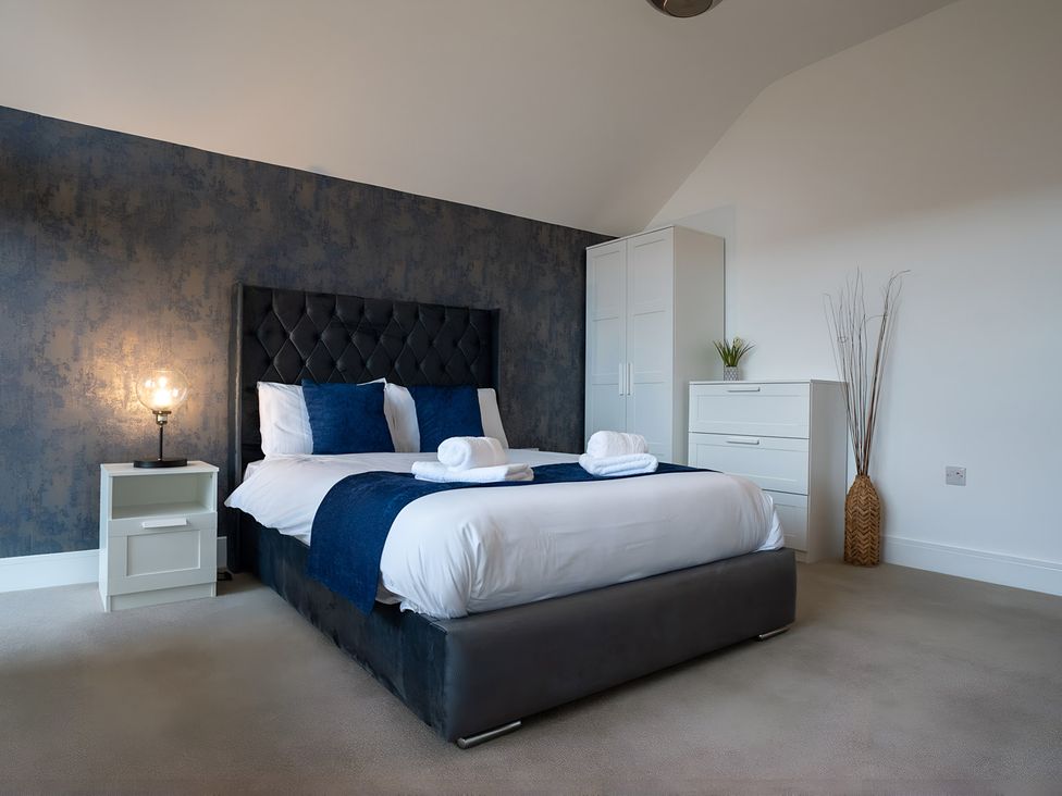 A bedroom with a bed and bedside table at The Galloway in Morpeth