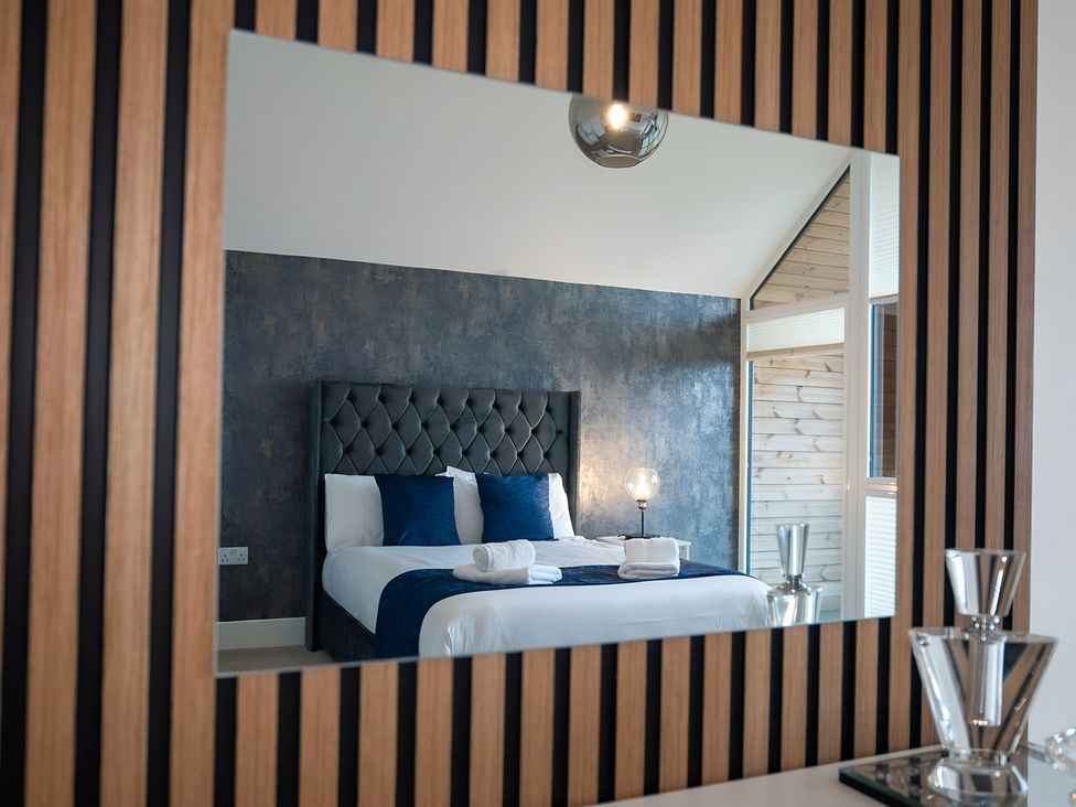 A bedroom featuring a bed with blue pillows and towels at The Galloway in Morpeth