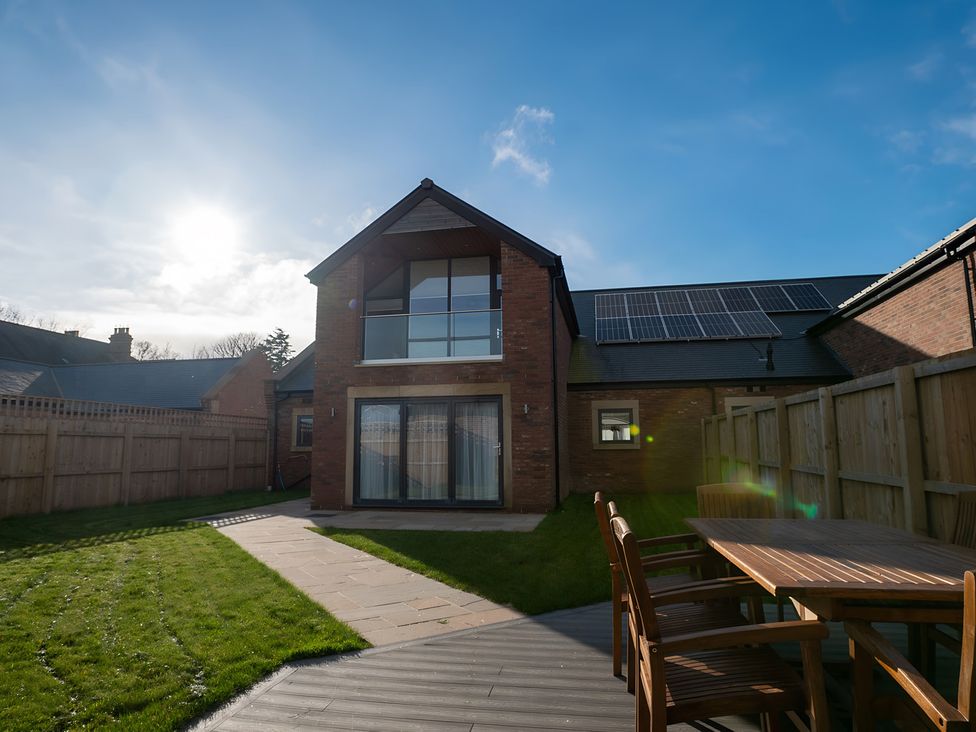 A garden with a house and patio seating at The Galloway in Morpeth