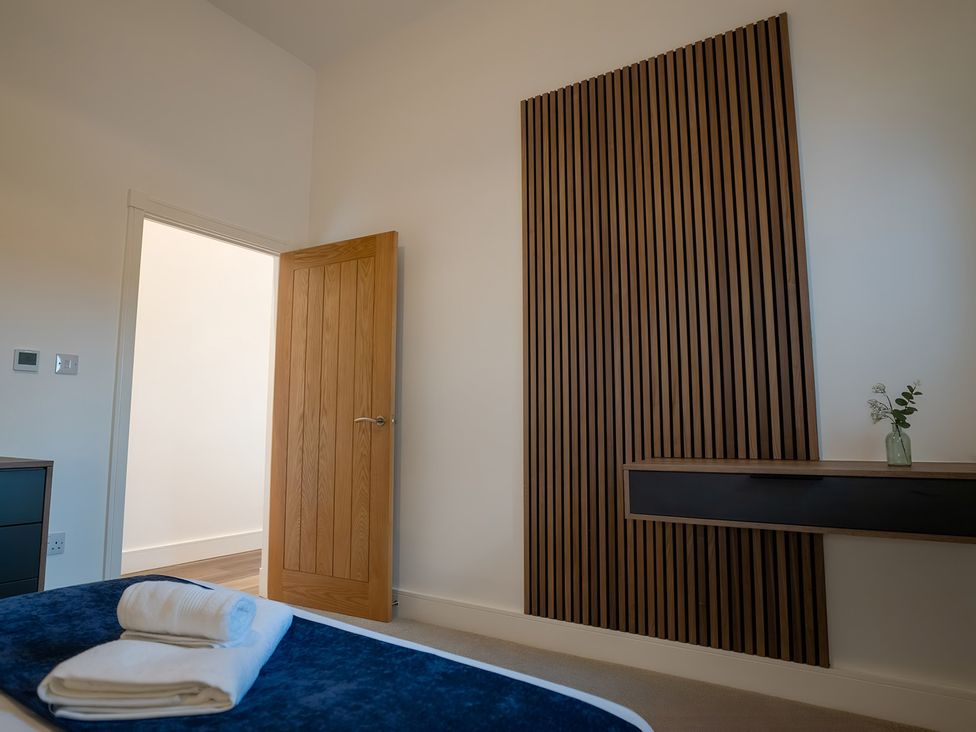 A bedroom with a bed and a door at The Shearling in Morpeth