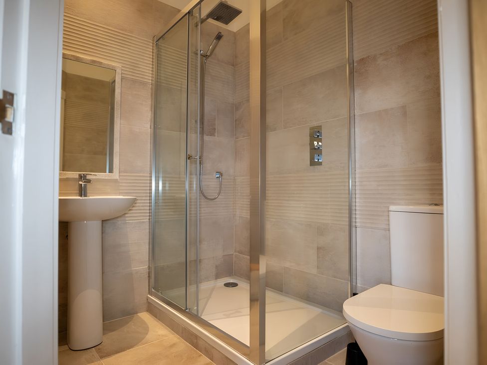 A bathroom with a shower, sink, and toilet at The Shearling in Morpeth