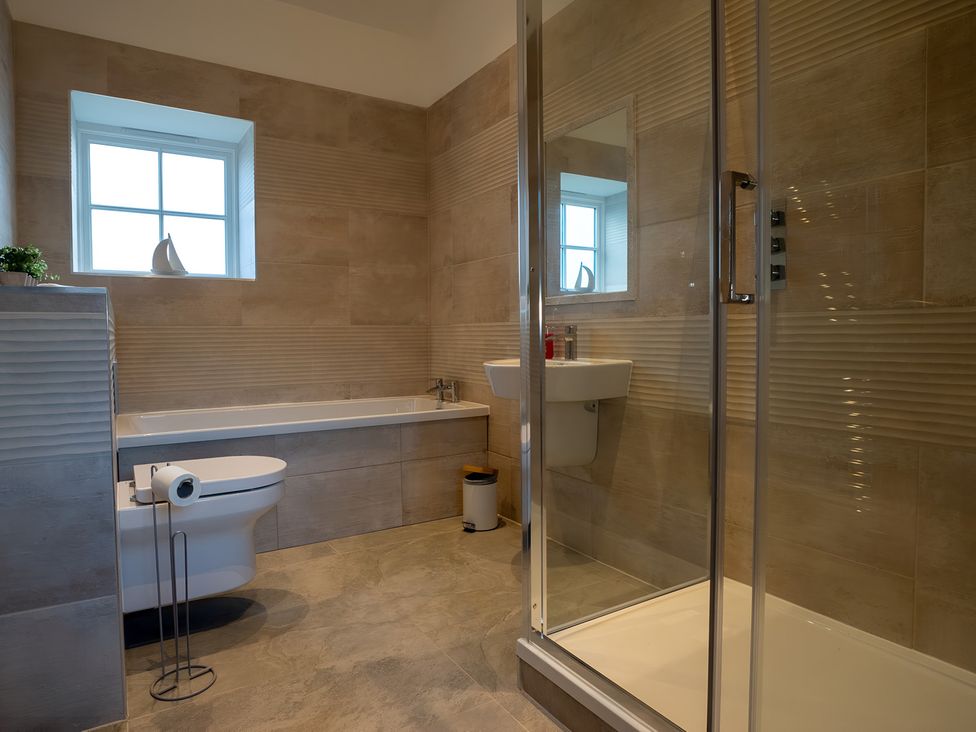 A bathroom with a bathtub, shower, sink, and toilet at The Shearling in Morpeth