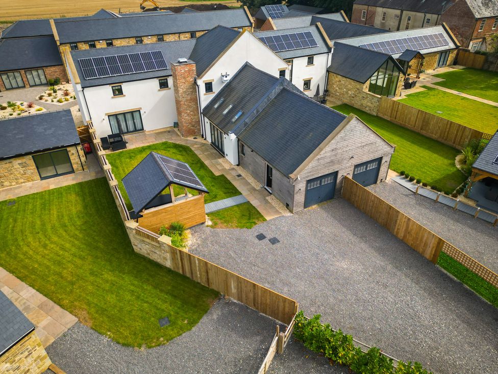 An outdoor view of buildings and a garden at The Newland in Morpeth