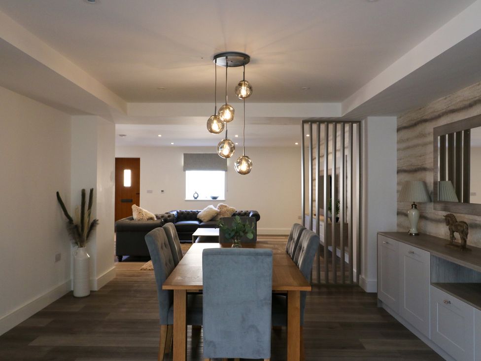 A dining room with a table and chairs overlooking a sofa at The Newland in Morpeth