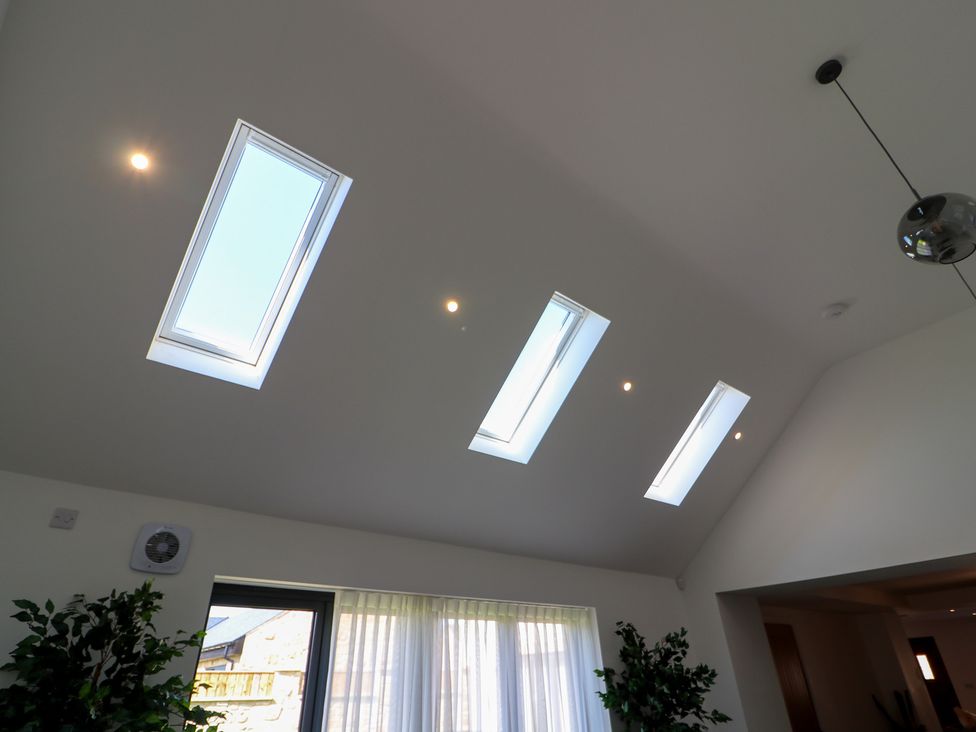 A ceiling with skylights and lights in a living room at The Newland in Morpeth
