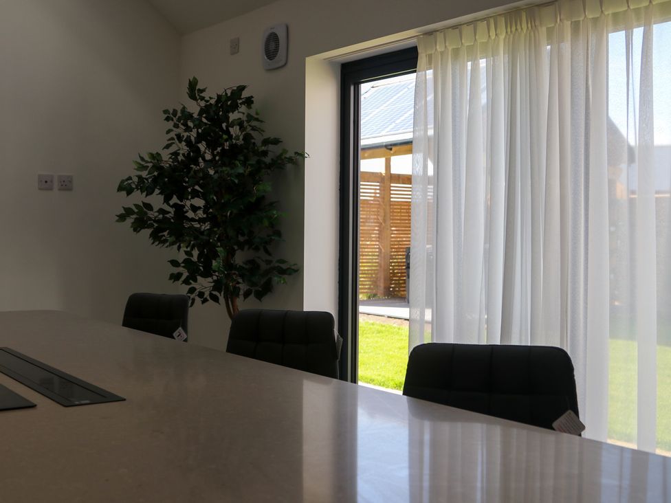 A dining room with a table, chairs, and a window at The Newland in Morpeth