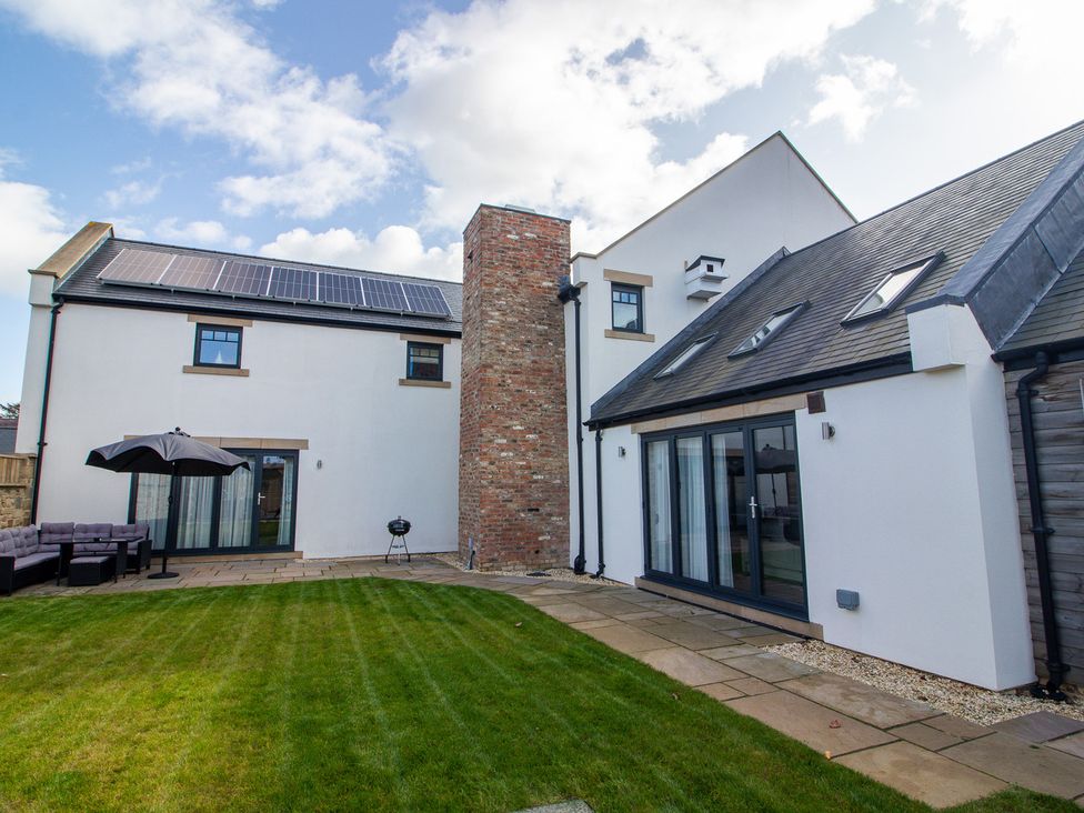 A house with solar panels and outdoor seating in the garden at The Newland in Morpeth