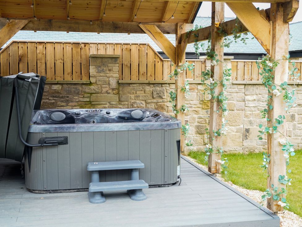 A hot tub on a deck surrounded by a wooden structure at The Newland in Morpeth