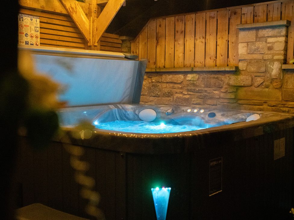A hot tub with wooden and stone walls at The Newland in Morpeth
