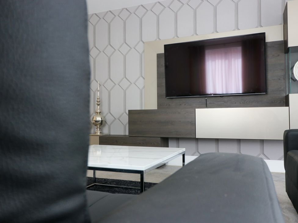 A living room with a television and coffee table at The Gavel in Morpeth