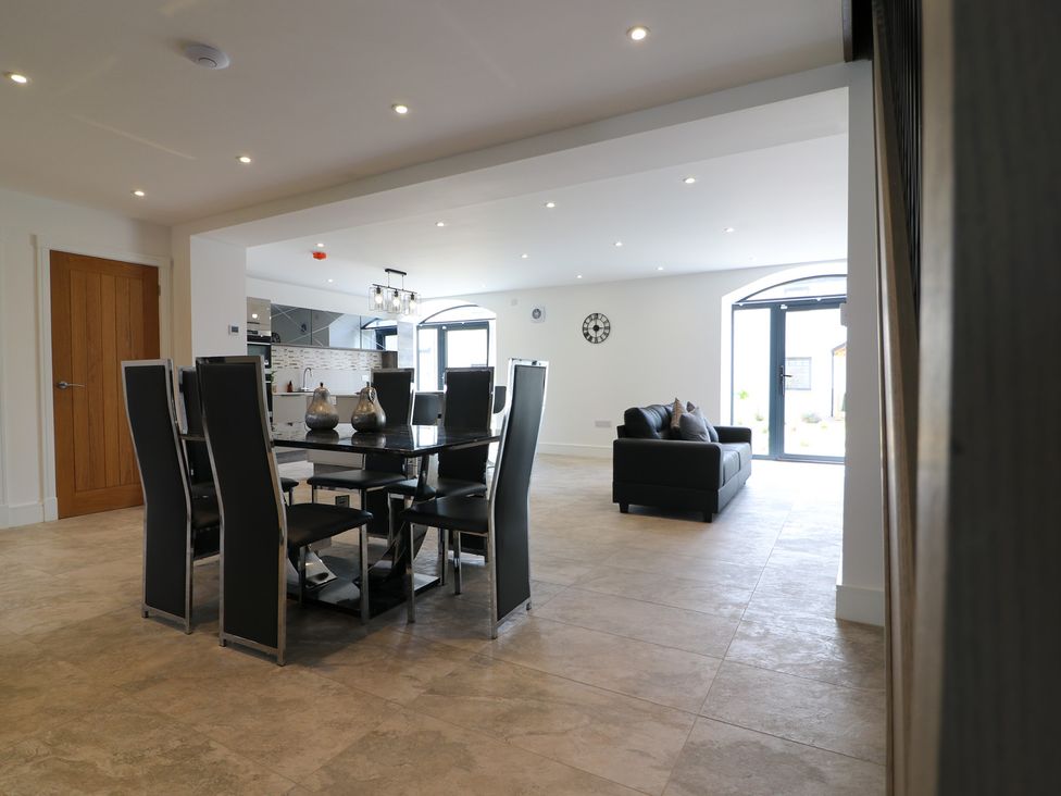 A dining room with a table and chairs adjacent to a living area at The Gavel in Morpeth