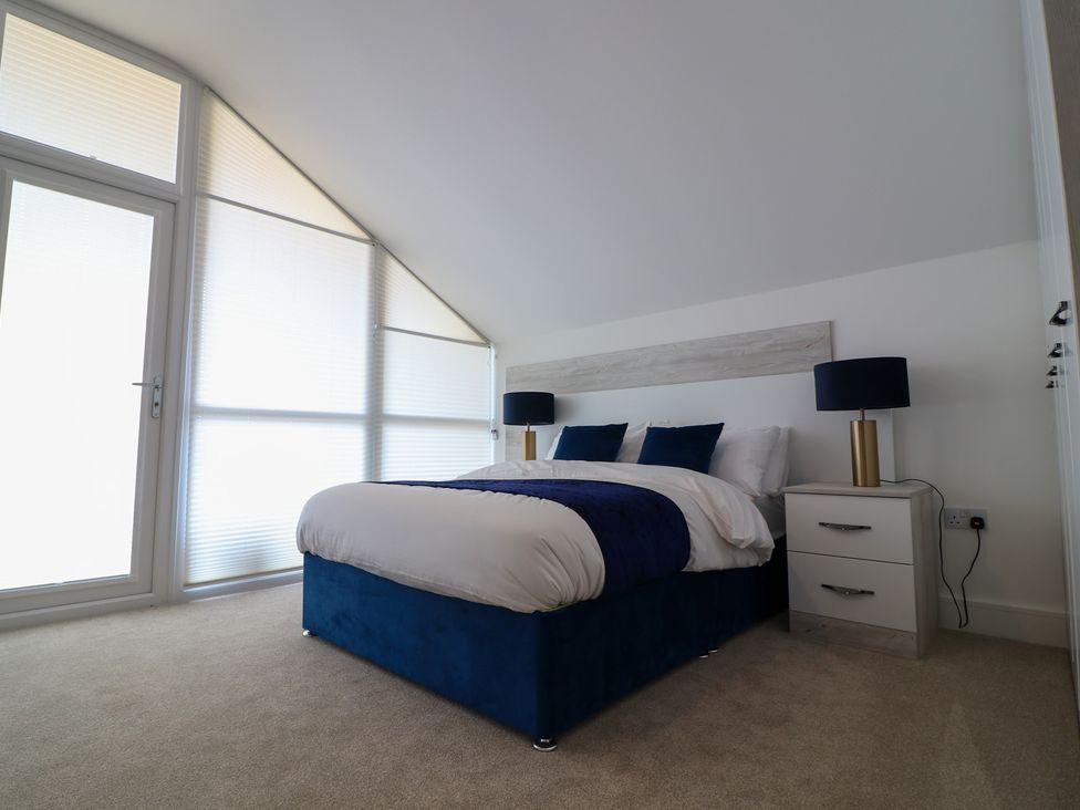 A bedroom with a bed, bedside table, and lamp at The Gavel in Morpeth