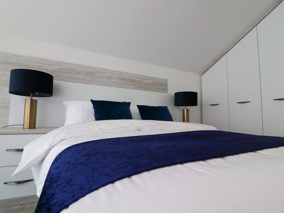 A bedroom with a bed and a lamp at The Gavel in Morpeth