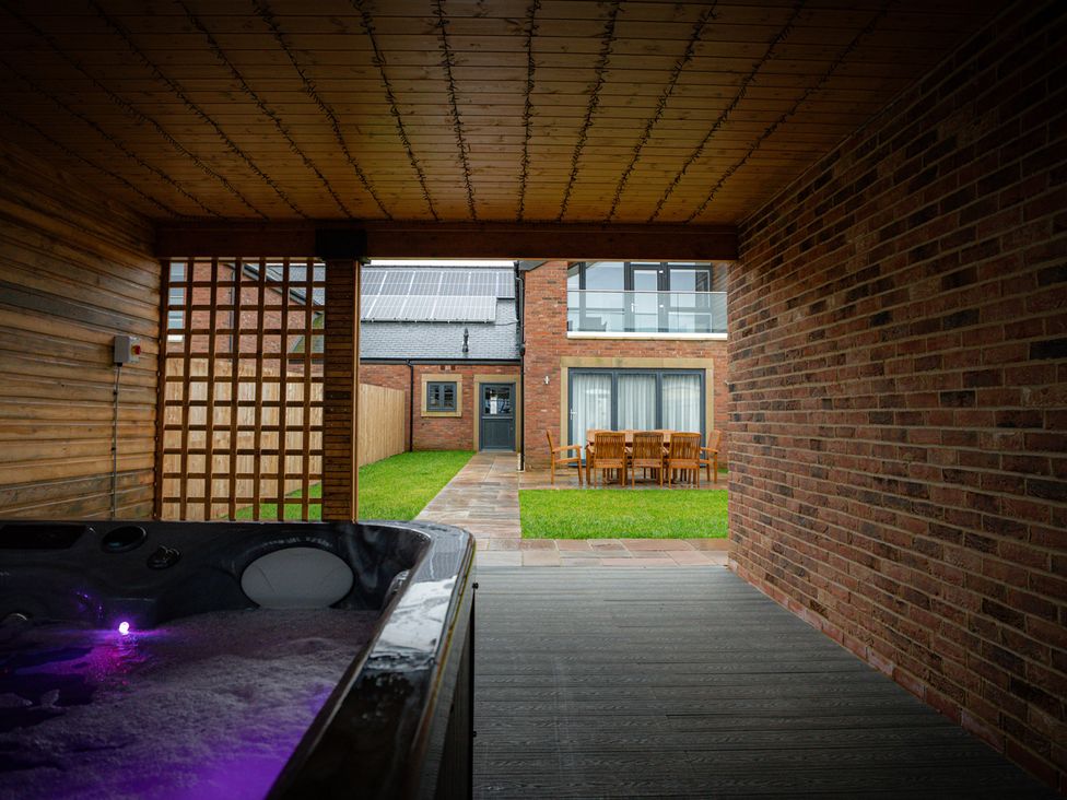 An outdoor area with a hot tub and dining table at The Gavel in Morpeth