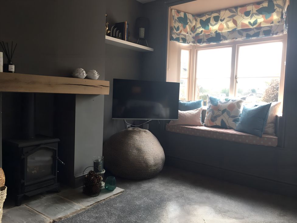 A living room with a fireplace and television at 29 Front Street Market Rasen