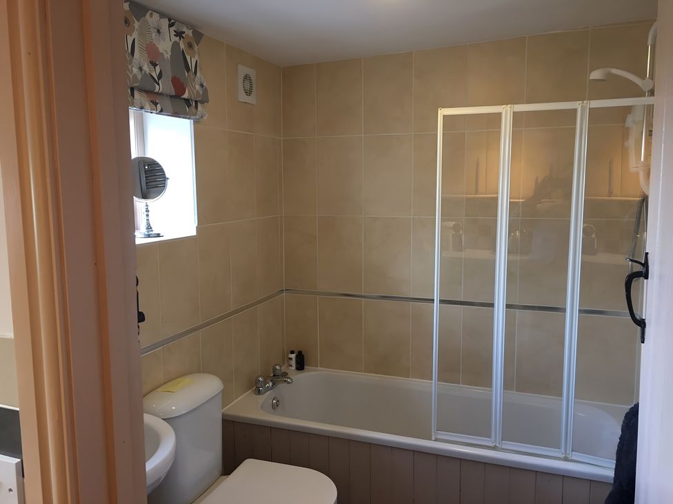 A bathroom with a bathtub and shower enclosure at 29 Front Street Market Rasen