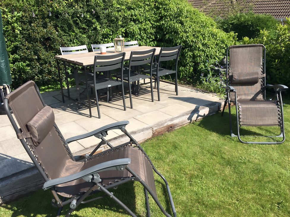 A garden with a table and chairs on a patio at 29 Front Street Market Rasen