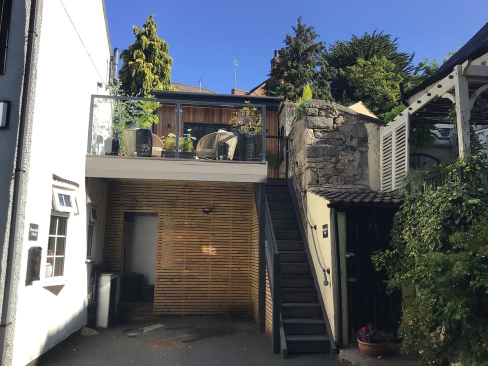 An outdoor area with stairs leading to a balcony at Honeysuckle Lodge in Knaresborough